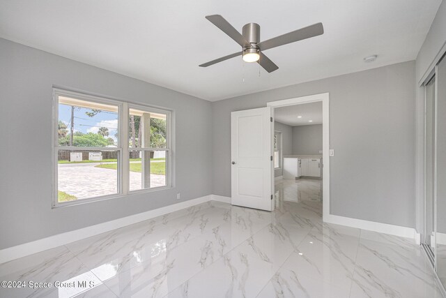 unfurnished bedroom featuring a closet, multiple windows, and ceiling fan