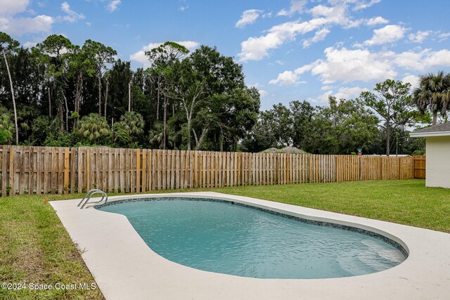 view of swimming pool featuring a yard