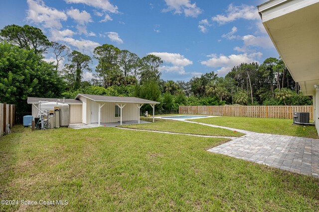 view of yard featuring an outbuilding, a fenced in pool, and a patio area