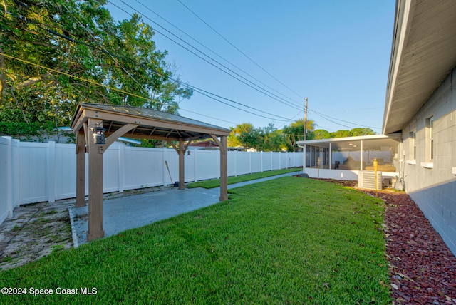 view of yard with a sunroom, a gazebo, and a patio area