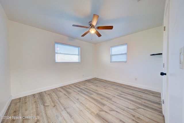 unfurnished room featuring a wealth of natural light, ceiling fan, and light wood-type flooring