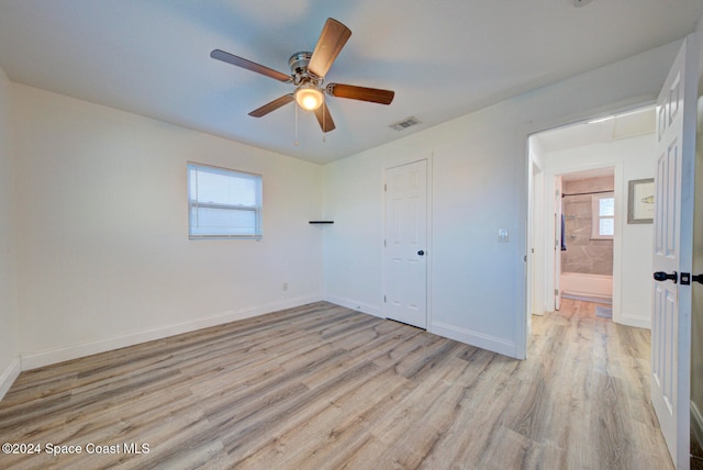 unfurnished bedroom with light hardwood / wood-style floors, multiple windows, and a closet