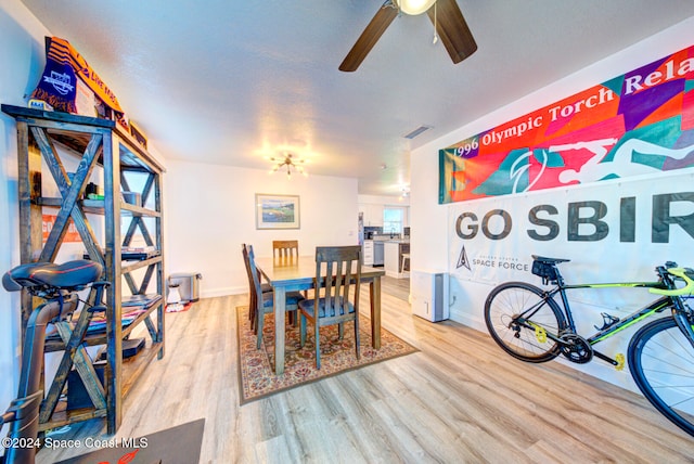 dining space featuring light hardwood / wood-style floors, ceiling fan, and a textured ceiling