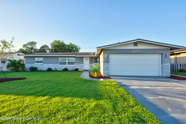 ranch-style home featuring a garage and a front lawn