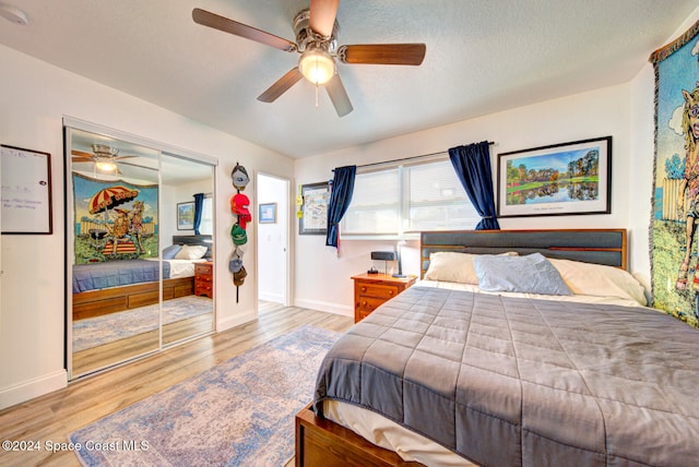 bedroom with ceiling fan, a textured ceiling, a closet, and light hardwood / wood-style flooring