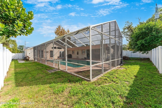 back of house featuring a fenced in pool, a yard, and glass enclosure