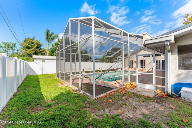 view of swimming pool featuring a lanai, a yard, and a patio area