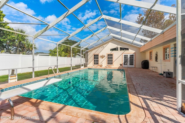 view of swimming pool featuring a patio and glass enclosure