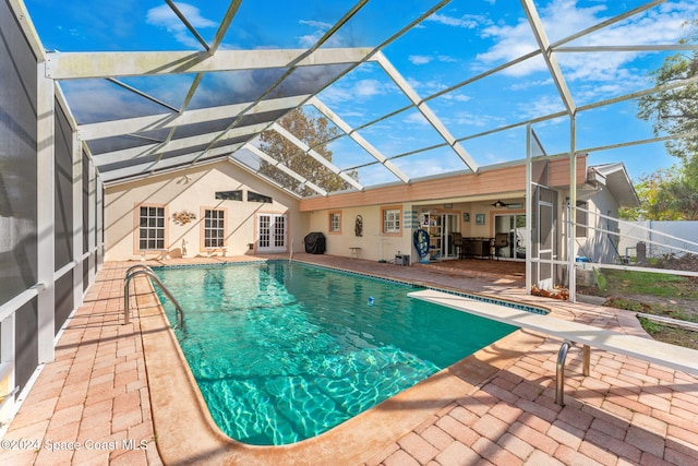 view of pool with ceiling fan, a patio, and glass enclosure