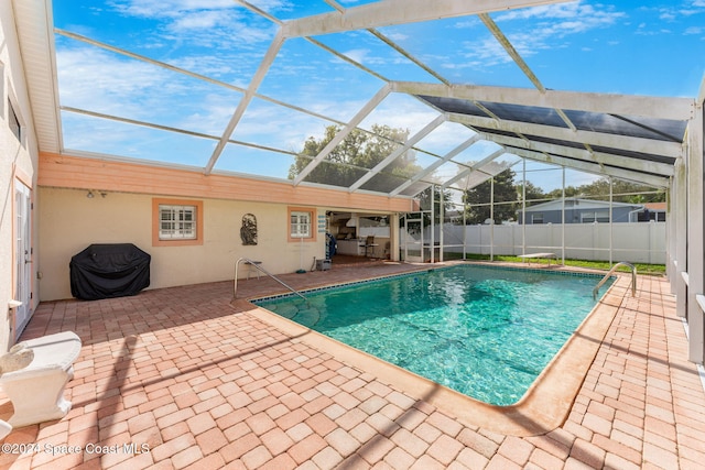 view of swimming pool with glass enclosure and a patio