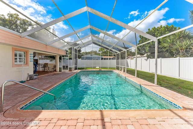 view of swimming pool featuring a lanai and a patio