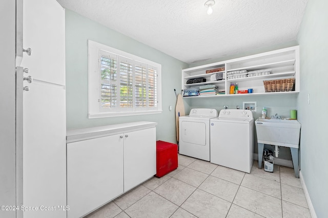 laundry room featuring light tile patterned flooring, separate washer and dryer, and a textured ceiling