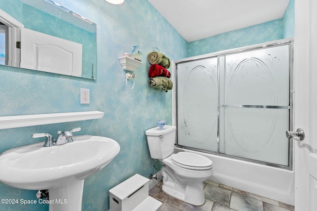 full bathroom featuring sink, a textured ceiling, enclosed tub / shower combo, and toilet