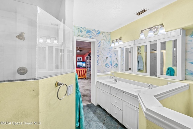 bathroom with vanity, tiled shower, and tile patterned floors