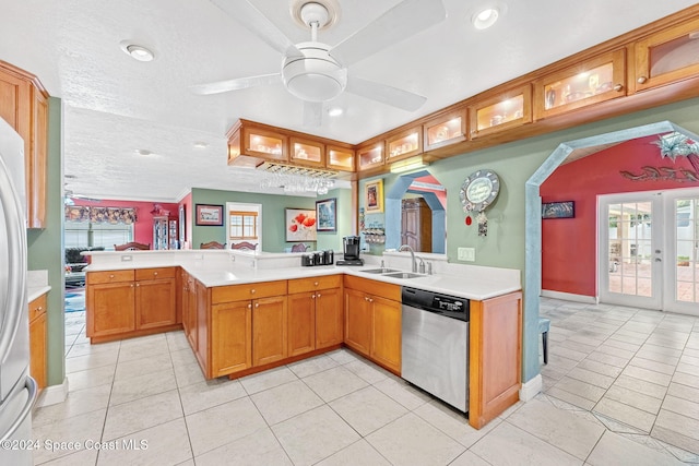 kitchen featuring kitchen peninsula, stainless steel dishwasher, sink, and light tile patterned floors