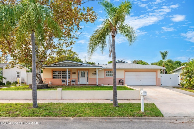 single story home featuring a garage, a front yard, and a porch