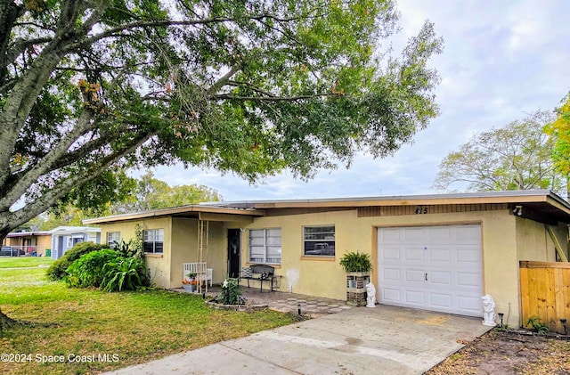 single story home featuring a front lawn and a garage