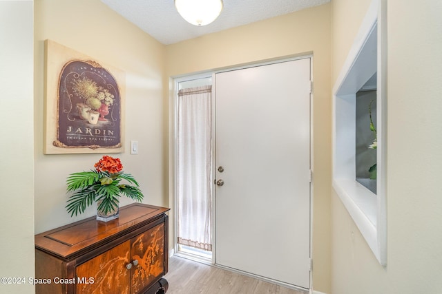 foyer entrance featuring a textured ceiling and light hardwood / wood-style floors