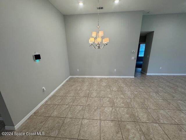 tiled empty room with a chandelier