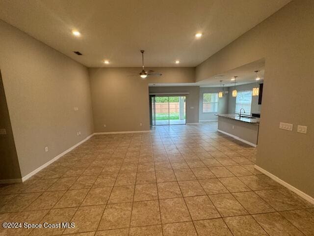 tiled spare room featuring ceiling fan and sink