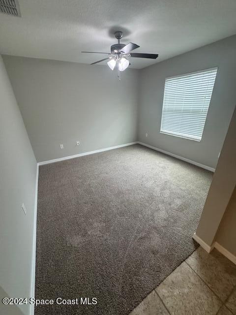 unfurnished room featuring ceiling fan and carpet floors