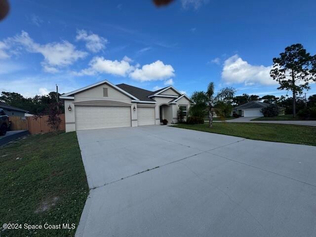 single story home featuring a garage and a front yard