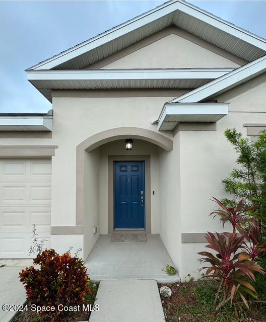 doorway to property with a garage