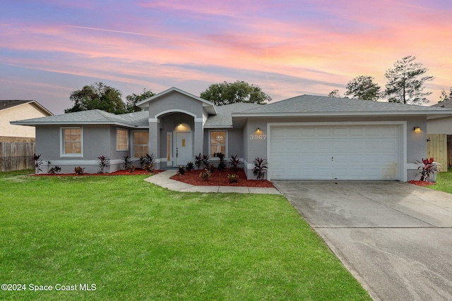 view of front of home featuring a garage and a yard