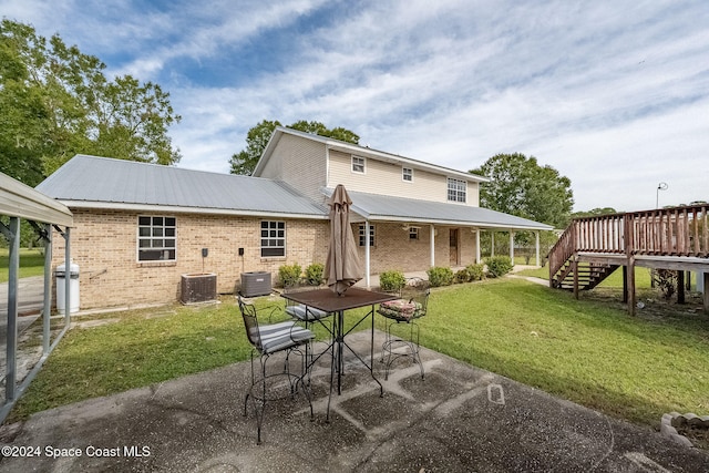 back of house featuring a yard, a deck, a patio area, and central air condition unit