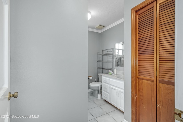 bathroom featuring tile patterned flooring, a textured ceiling, toilet, vanity, and ornamental molding