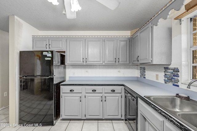kitchen with light tile patterned floors, sink, gray cabinets, and black appliances