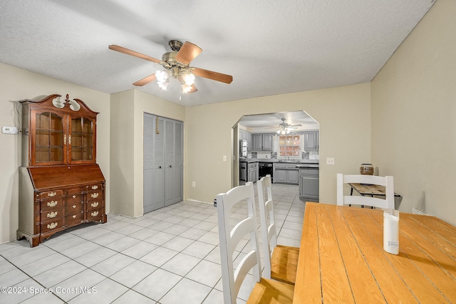dining space with ceiling fan, light tile patterned floors, and a textured ceiling
