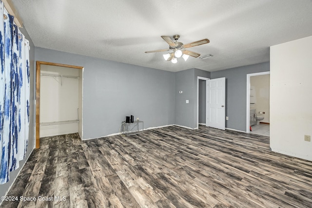 unfurnished bedroom with ceiling fan, dark hardwood / wood-style flooring, a textured ceiling, and a closet