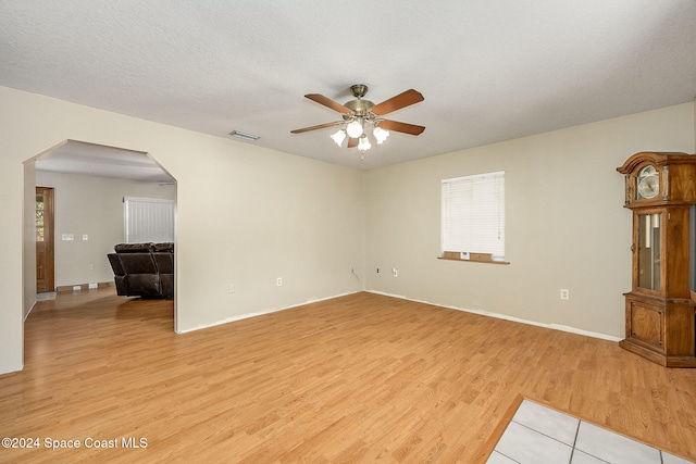 unfurnished room with ceiling fan, light hardwood / wood-style flooring, and a textured ceiling