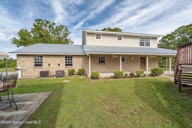 back of property with cooling unit, a patio area, and a lawn