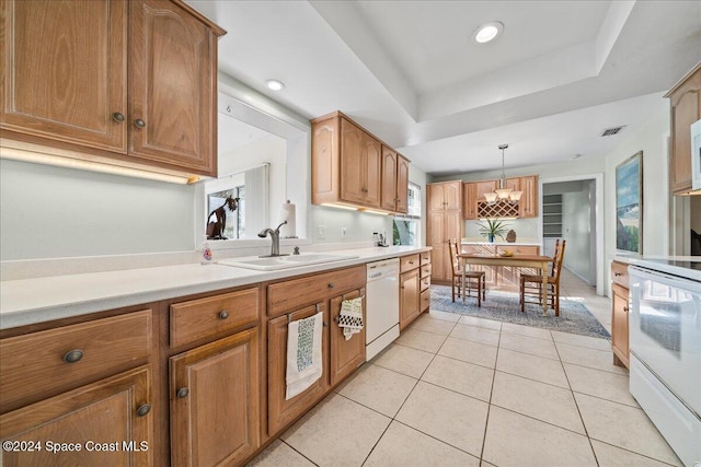 kitchen featuring white appliances, a raised ceiling, sink, light tile patterned floors, and decorative light fixtures