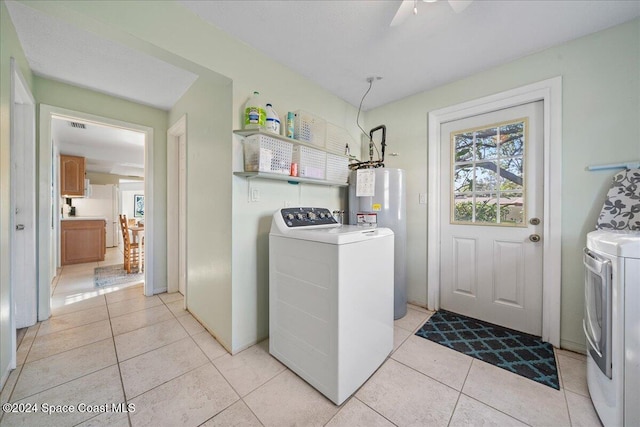 washroom with ceiling fan, water heater, light tile patterned floors, and washing machine and clothes dryer