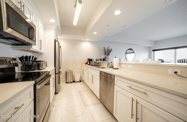 kitchen featuring white cabinets, sink, light stone counters, and stainless steel appliances