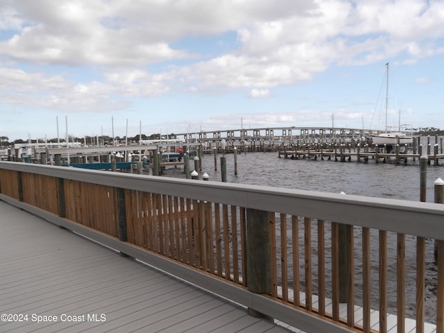 wooden deck featuring a water view and a boat dock