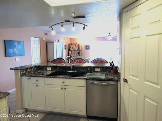 kitchen featuring white cabinetry, sink, dark stone countertops, stainless steel dishwasher, and a textured ceiling