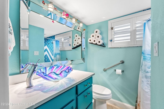 bathroom featuring vanity, toilet, and walk in shower