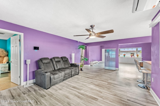 living room with ceiling fan and light wood-type flooring