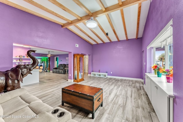 living room featuring beam ceiling, light hardwood / wood-style floors, high vaulted ceiling, and ceiling fan