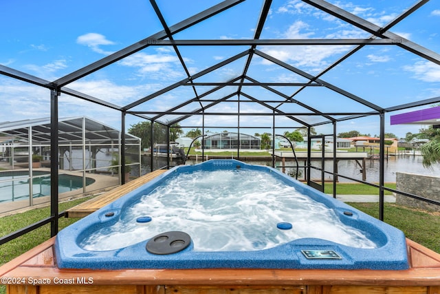 view of swimming pool featuring a water view, a lanai, and an outdoor hot tub