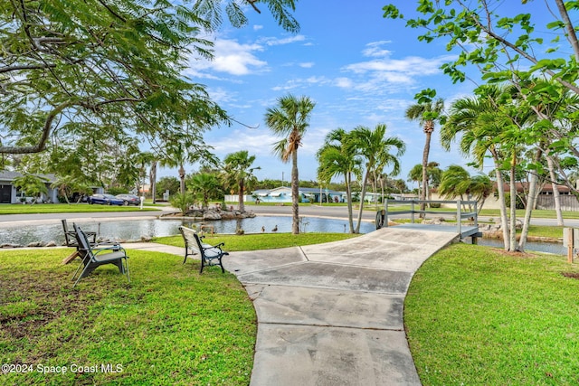 view of community with a lawn and a water view