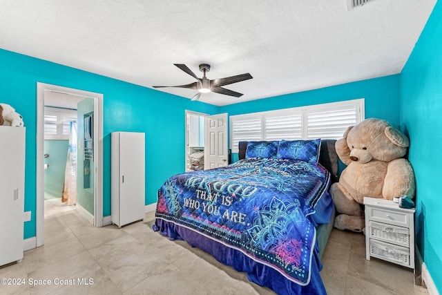 bedroom with white refrigerator, ceiling fan, and connected bathroom