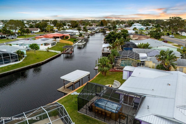 aerial view at dusk featuring a water view