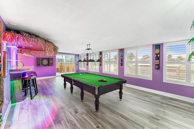 rec room with hardwood / wood-style floors, plenty of natural light, a textured ceiling, and pool table