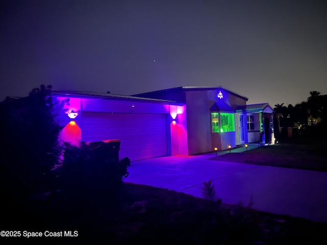 back house at twilight featuring a garage