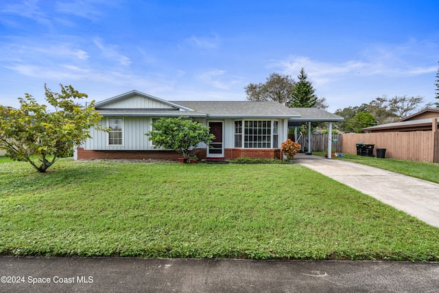 ranch-style house with a front yard and a carport